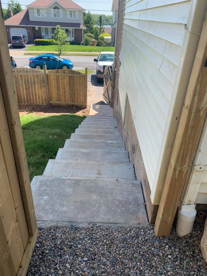 Concrete steps leading down side of home